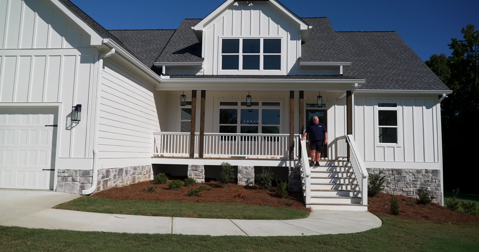 104 Bob White Drive: white board-and-batten craftsman with a covered front porch, stone skirt and two-car garage