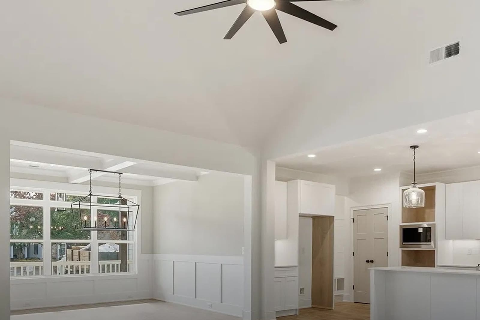 Vaulted family room open to the dining room and white kitchen