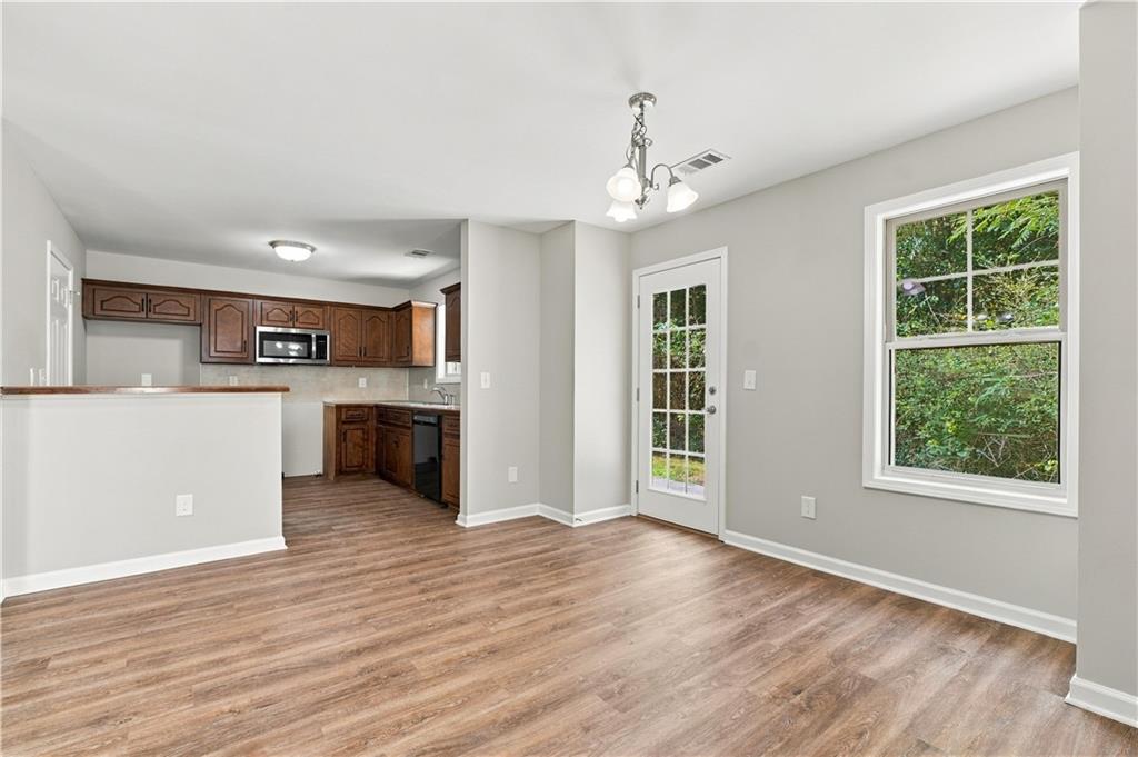 Open dining area and kitchen with new flooring and fresh paint