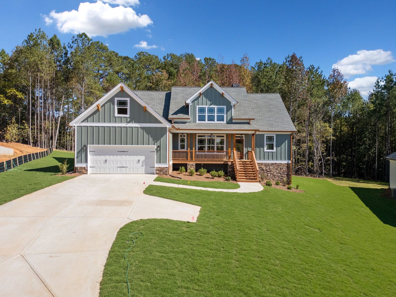 Sage craftsman home with cedar porch and two-car garage