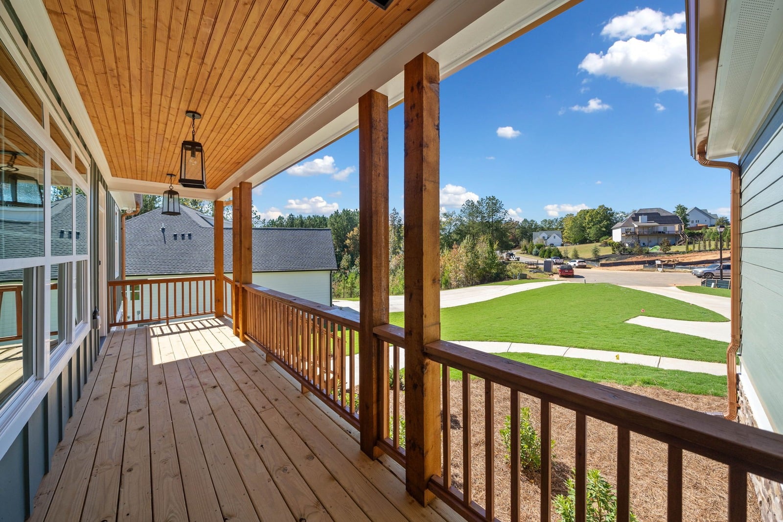 Covered front porch with pine tongue-and-groove ceiling, cedar posts and lantern pendants