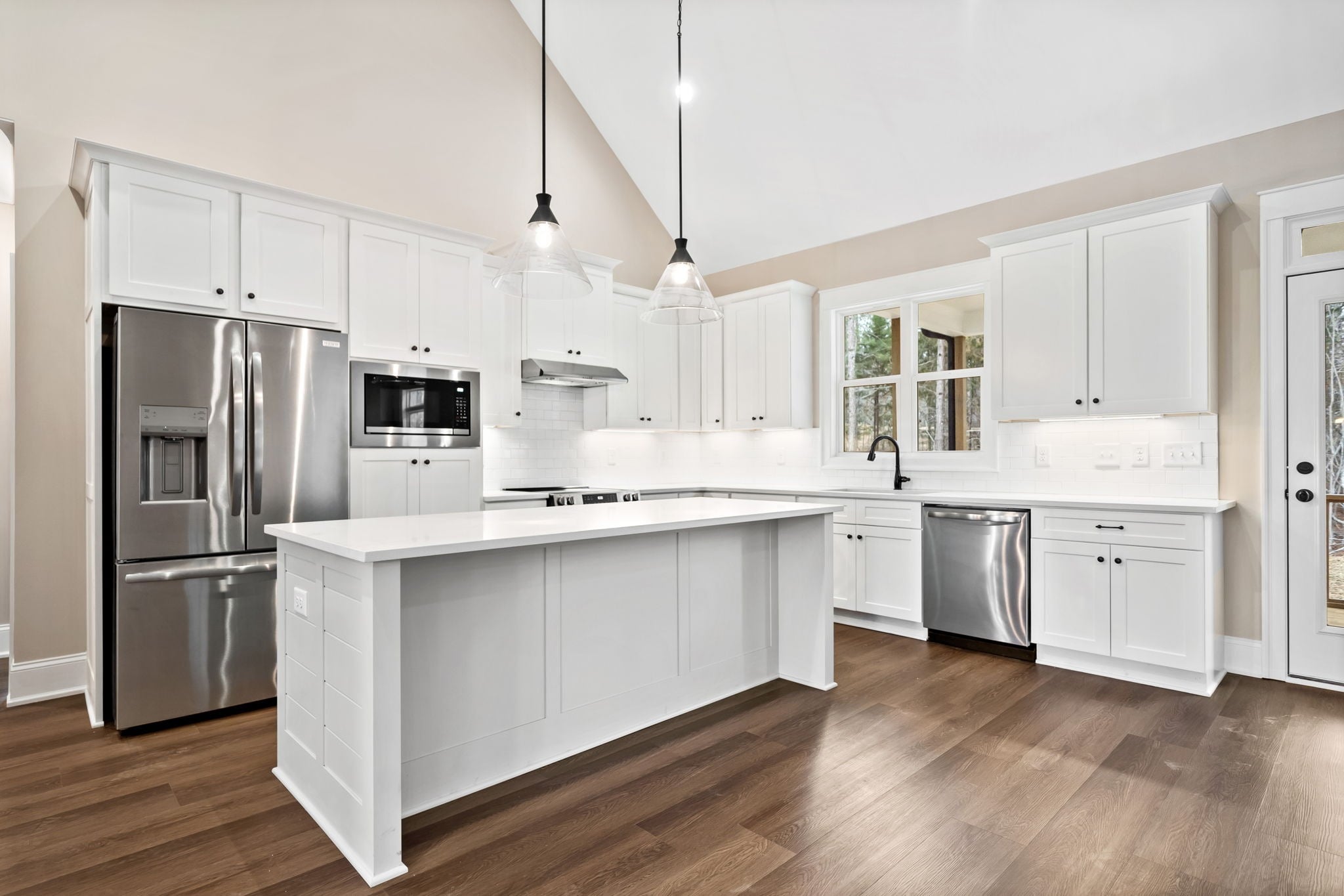 White kitchen with glass pendant lights over the island