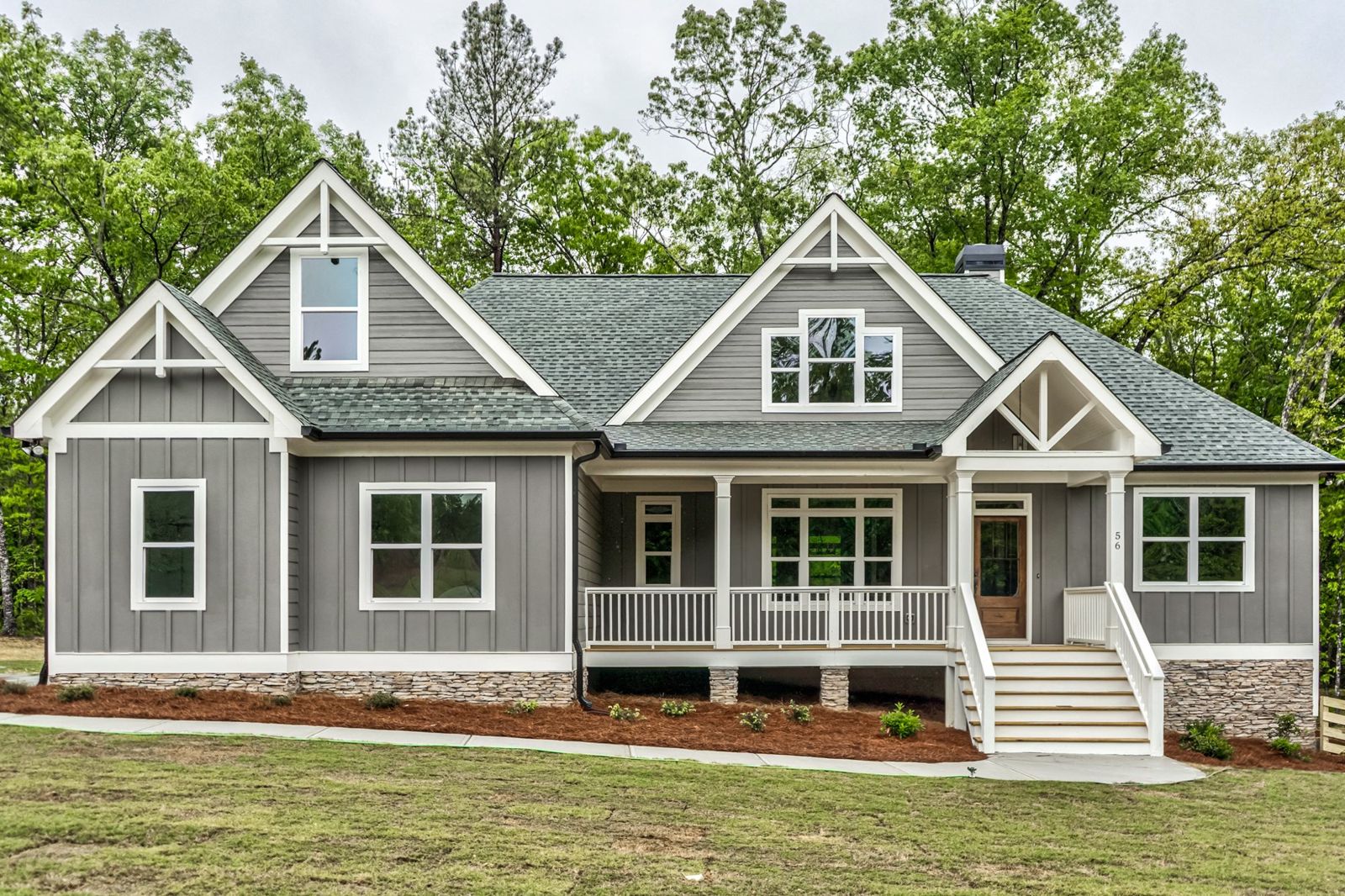Hemlock Falls plan built by Riverstone Homes: gray board and batten craftsman with white trim and a covered front porch