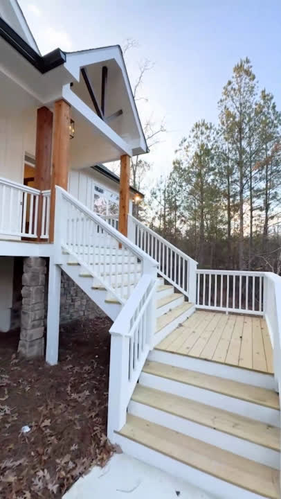 White porch stairs with cedar posts and stacked stone piers